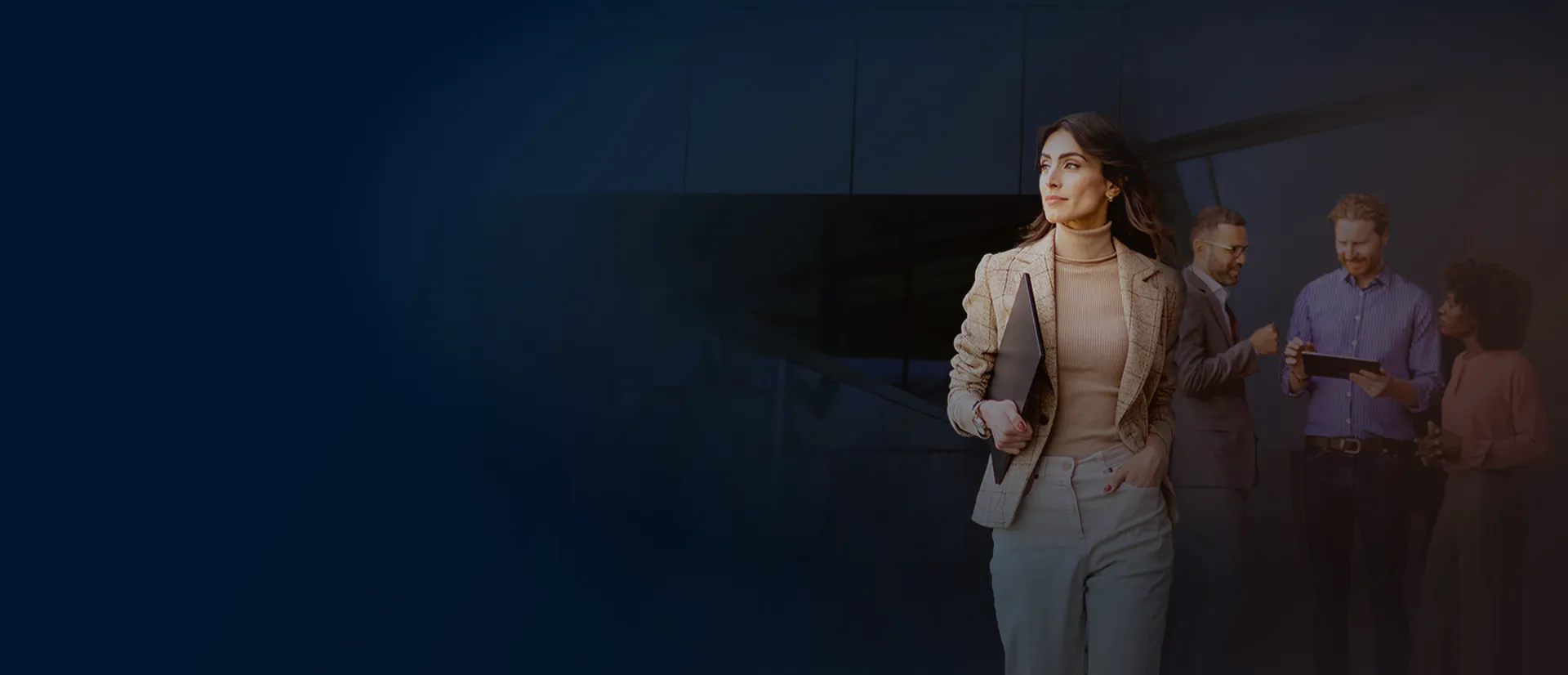 A photo of a women confidently walking forward while a few other people stand behind. 
